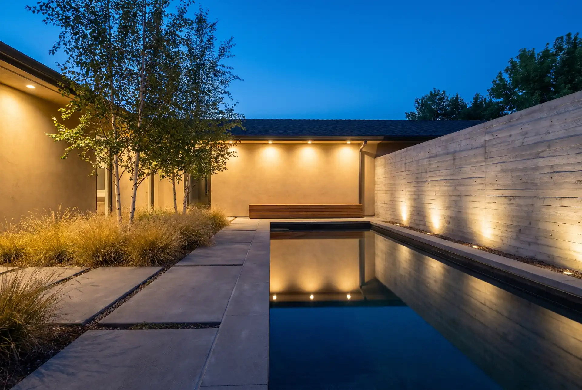 Evening courtyard. 45 ft lap pool, board-formed retaining wall.